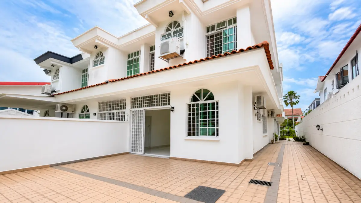 White modern residence exterior with a tiled courtyard, arched windows, and palm trees against a blue sky.