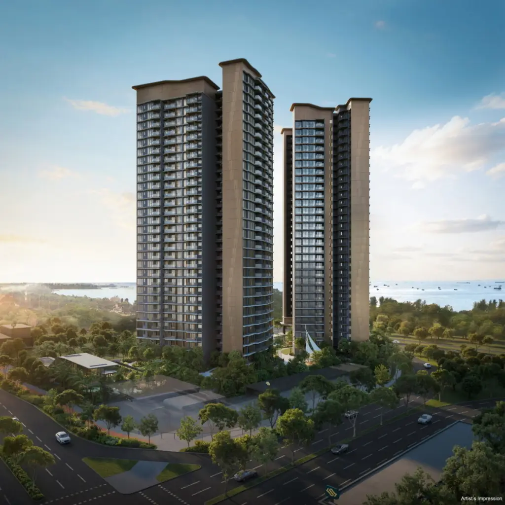Three tall modern residential towers rise behind a tree-lined roundabout by the coast under a blue sky.