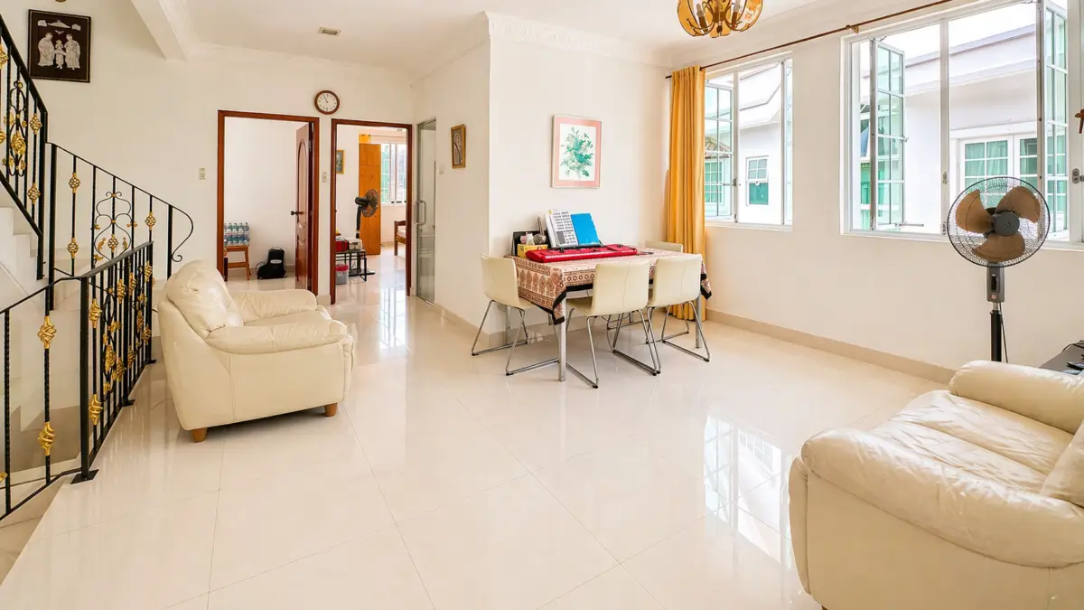 Bright living and dining area with cream sofas, a dining table, and large windows with yellow curtains; glossy tiled floor reflects light.