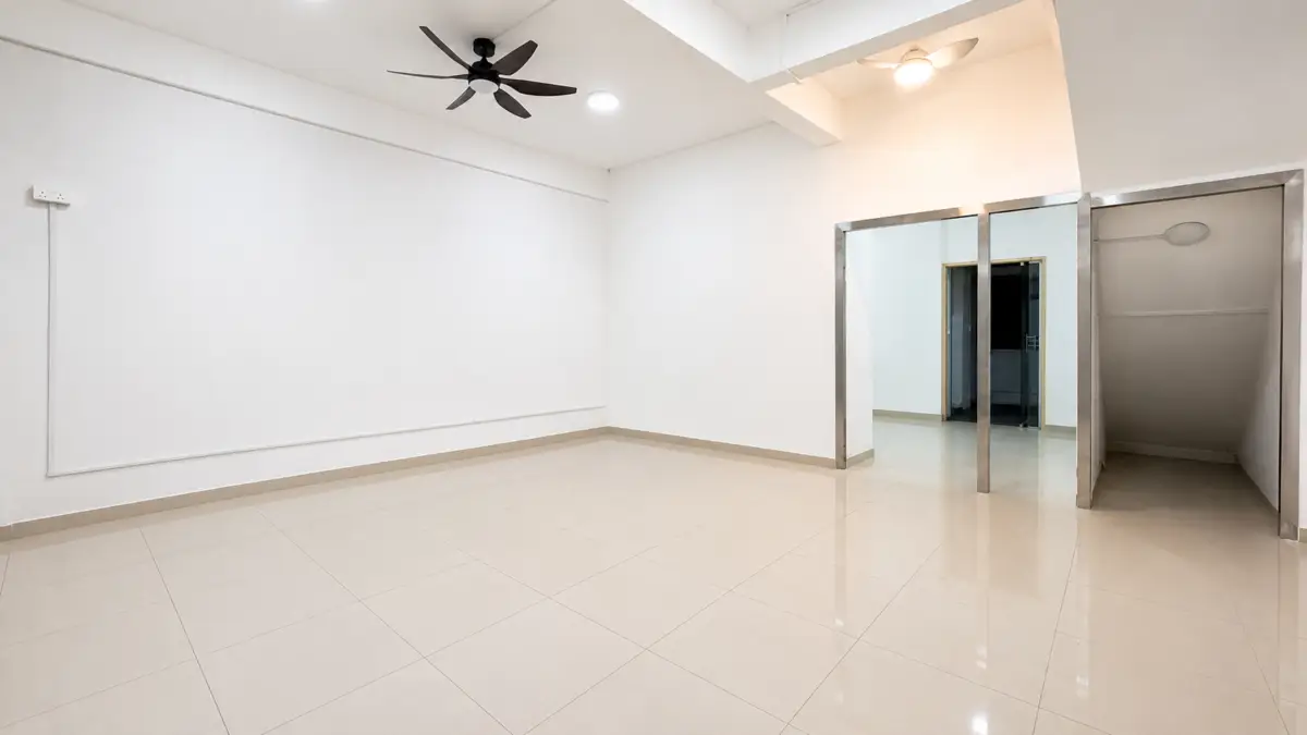 Empty white-walled room with a beige tile floor, two ceiling fans, and a metal-framed doorway to another area.