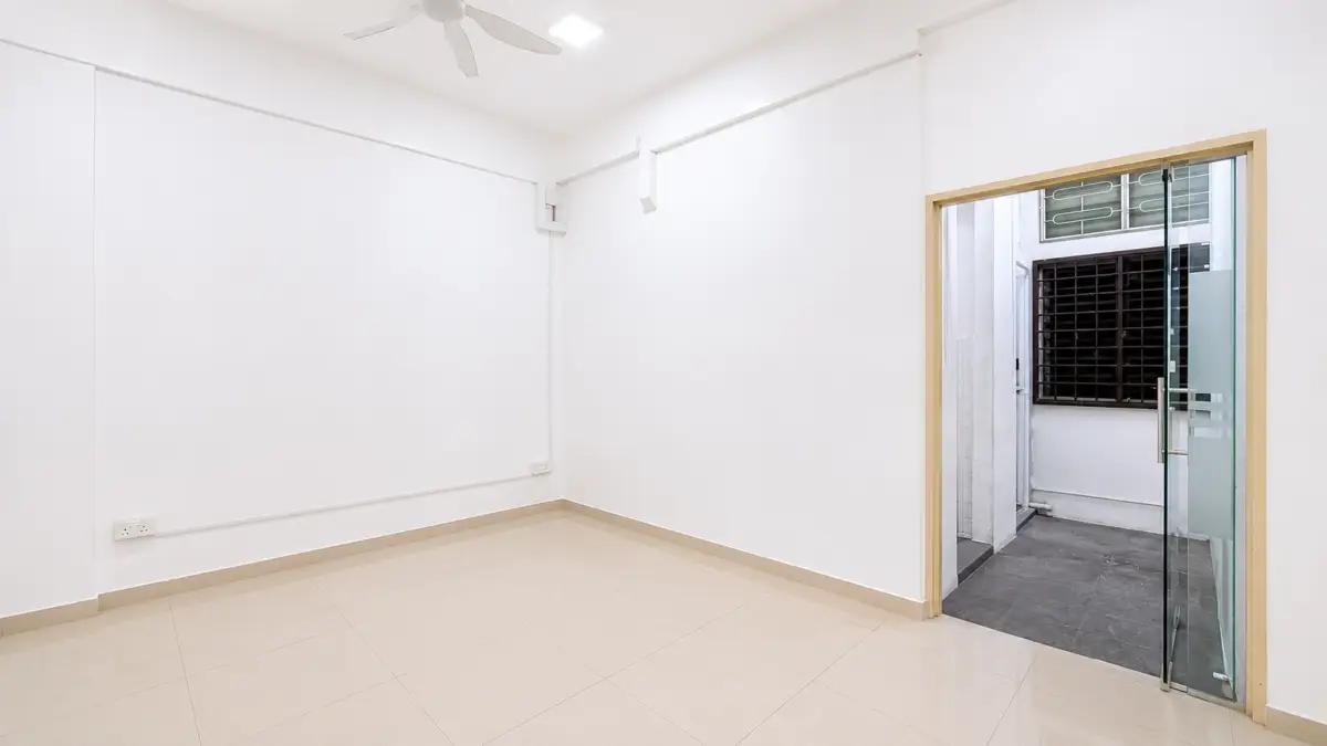 Empty white room with beige tile floor, ceiling fan, and a glass door opening to an outdoor area with a barred window seen outside the doorway.