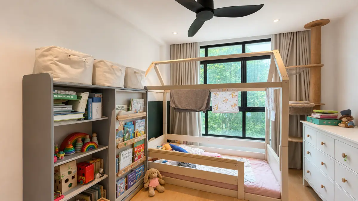 Child's bedroom with a wooden bunk bed, storage shelves, and a dresser, near a large window with greenery outside