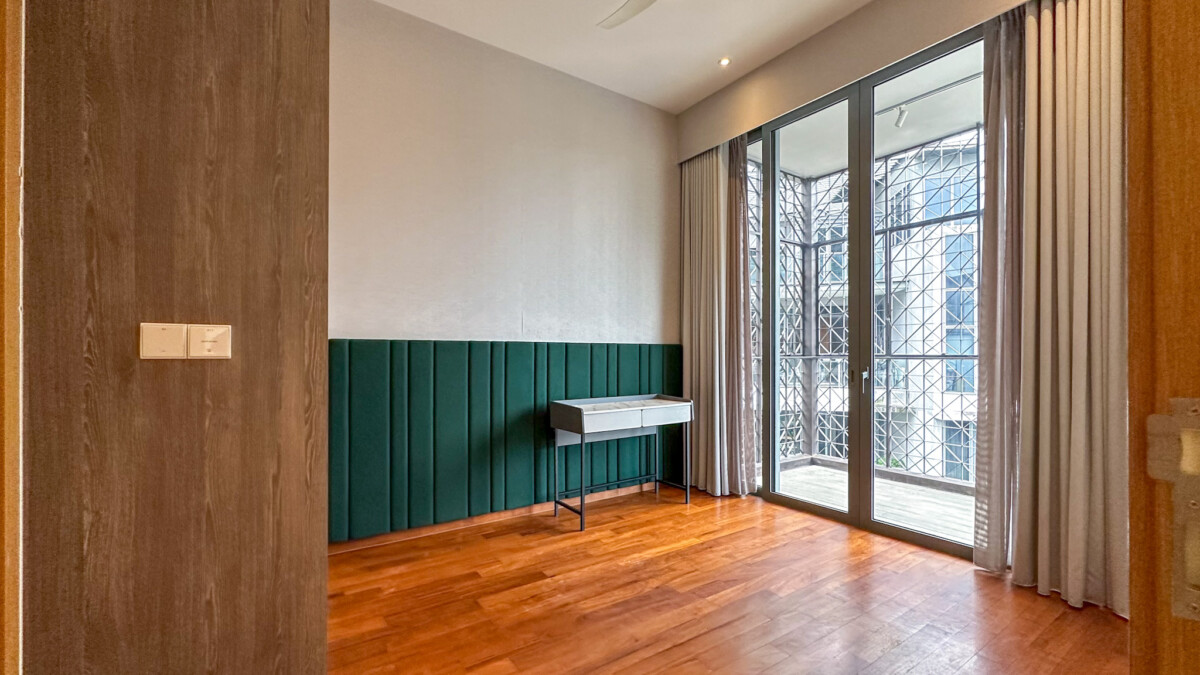 Modern empty room with warm wooden floor, teal upholstered wall panel, and a small white console table by the wall.