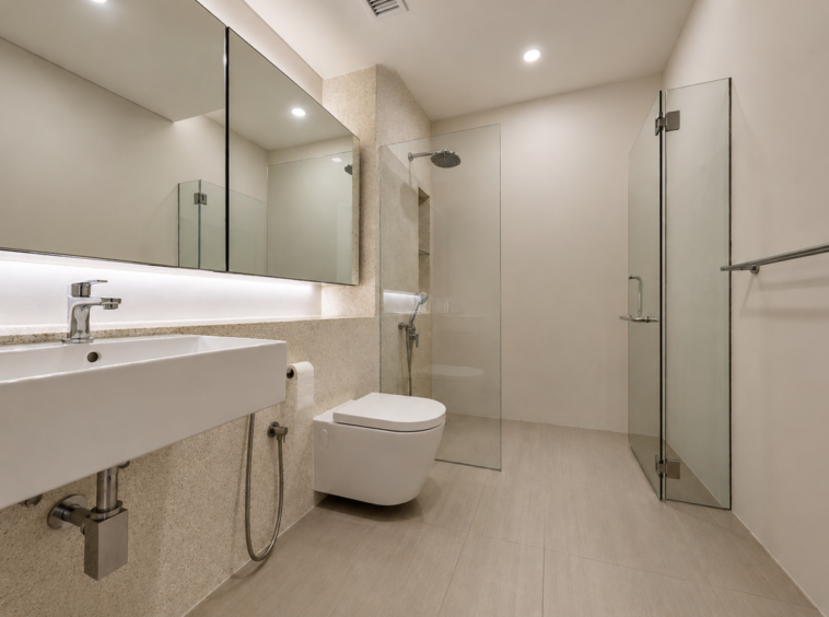Modern bathroom with a large mirrored cabinet above a rectangular white sink, chrome faucet, and glass shower enclosure.