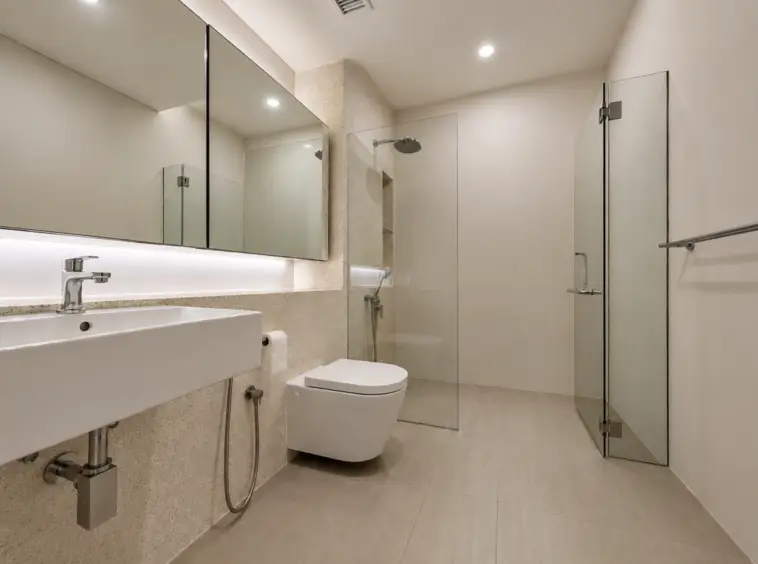 Modern bathroom with a large mirrored cabinet above a rectangular white sink, chrome faucet, and glass shower enclosure.