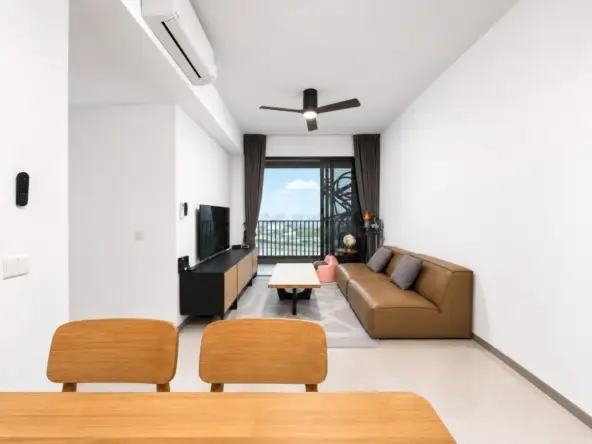 Bright modern living room with a brown leather sofa facing a black TV console, coffee table, and a balcony window with dark curtains. A wooden dining table and chairs are in the foreground; city view visible through the glass door.