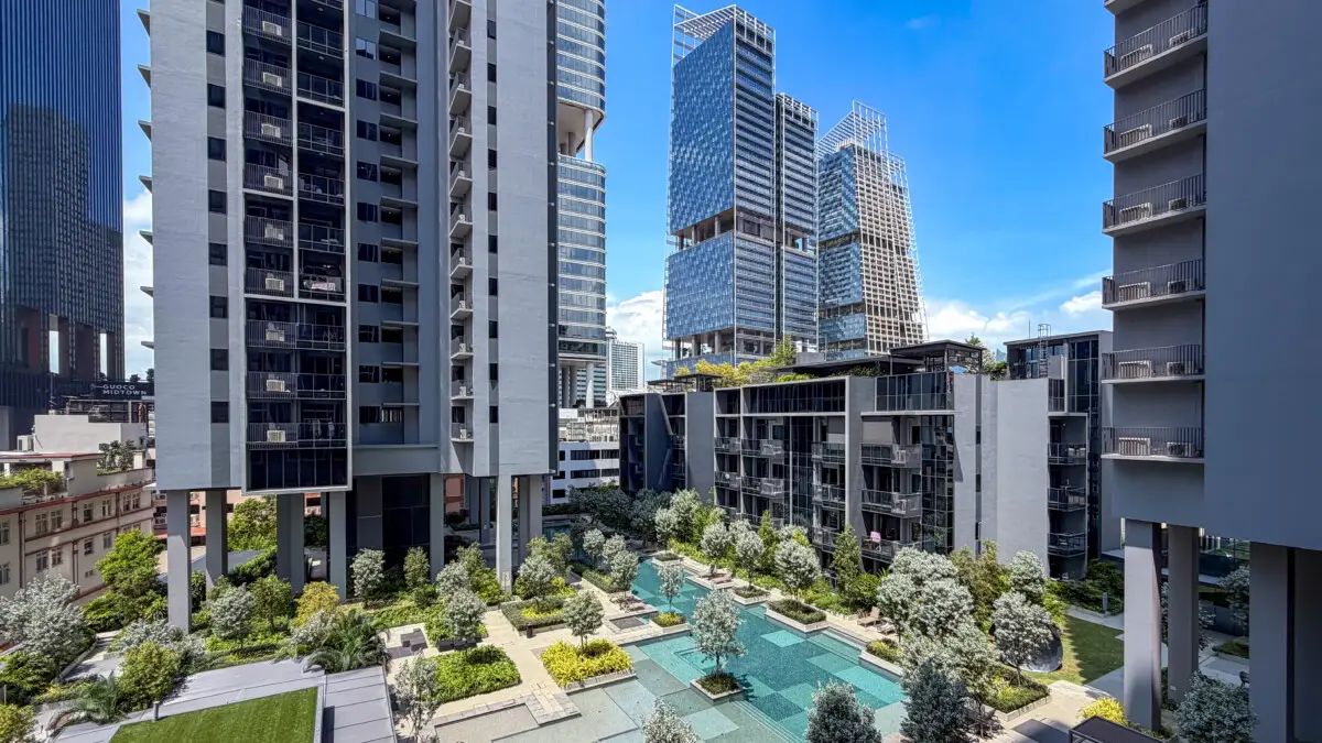 Modern high-rise residential complex with a landscaped courtyard and shallow reflecting pool.